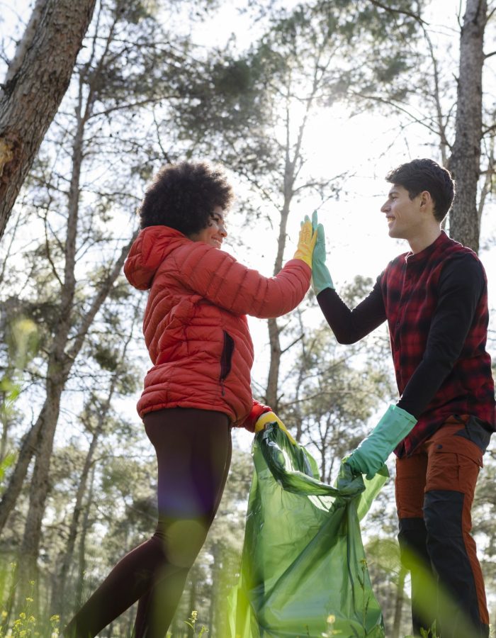multiracial volunteers collect garbage in the forest